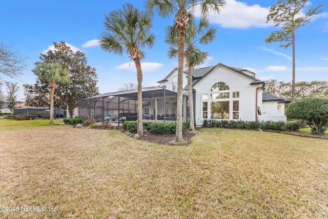 back of house featuring a lanai and a lawn