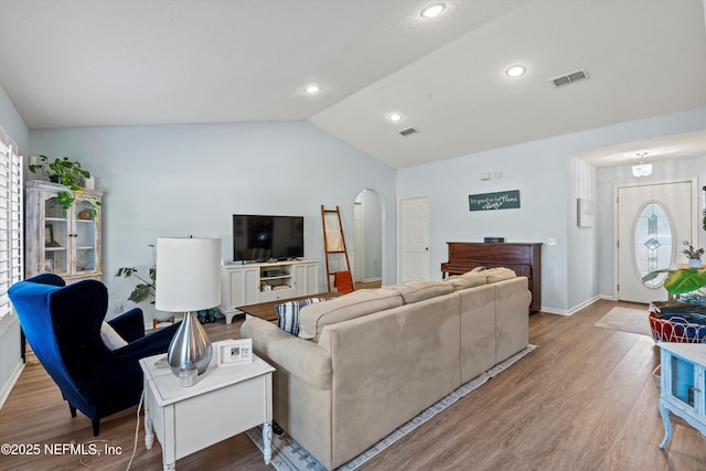 living room featuring hardwood / wood-style flooring, vaulted ceiling, and a wealth of natural light