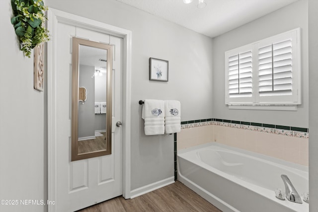 bathroom featuring hardwood / wood-style flooring and a bathing tub