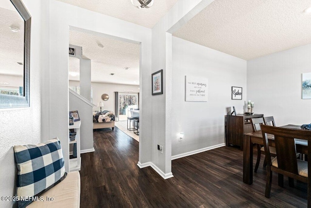 corridor featuring dark wood-type flooring and a textured ceiling