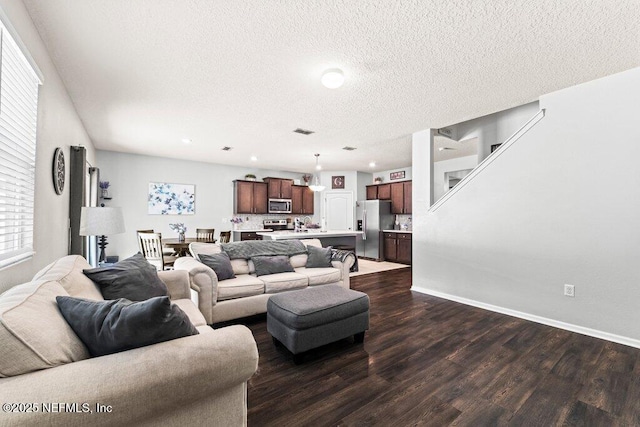 living room with plenty of natural light, dark hardwood / wood-style floors, and a textured ceiling