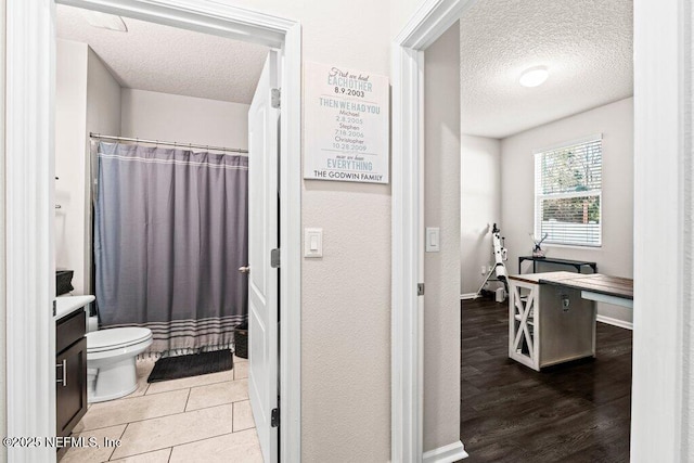 bathroom with vanity, toilet, a textured ceiling, and a shower with shower curtain