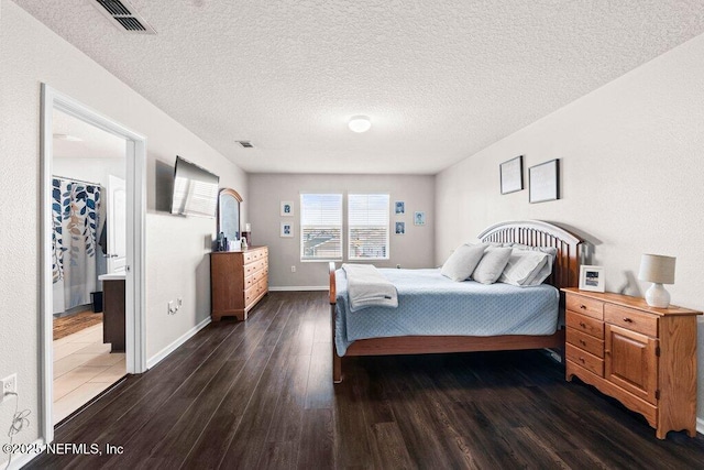 bedroom featuring dark hardwood / wood-style flooring, connected bathroom, and a textured ceiling