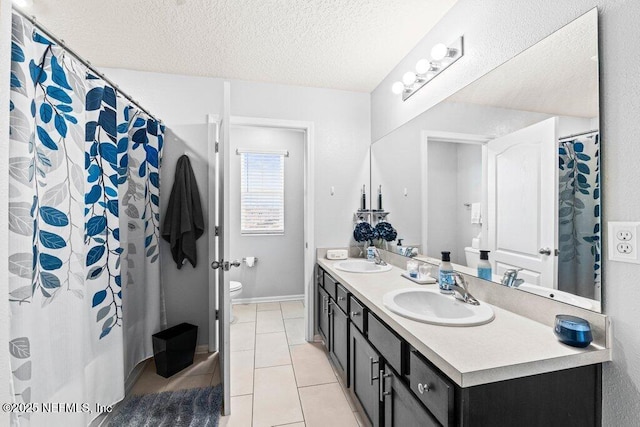 bathroom featuring tile patterned flooring, vanity, toilet, and a textured ceiling