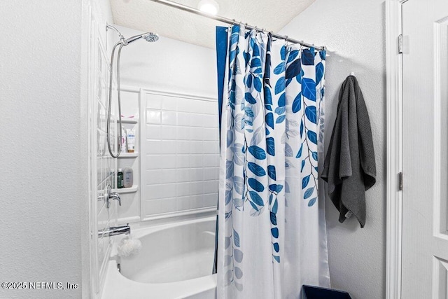 bathroom with a textured ceiling and shower / bath combo