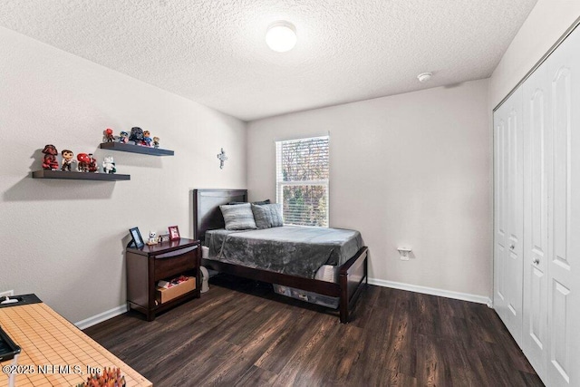 bedroom with dark hardwood / wood-style floors, a textured ceiling, and a closet