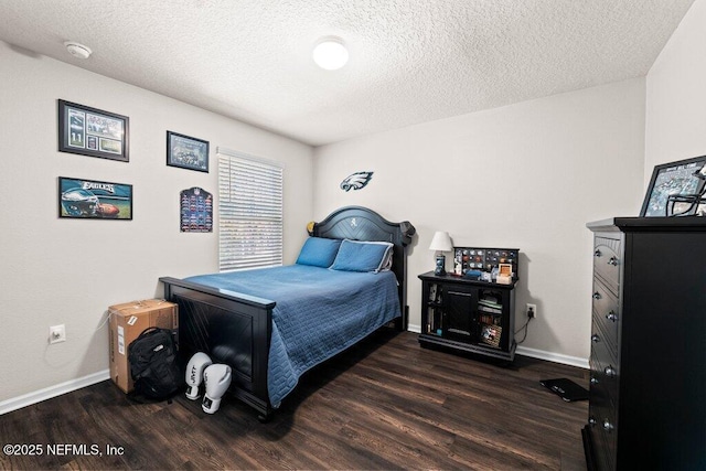 bedroom featuring dark hardwood / wood-style flooring and a textured ceiling