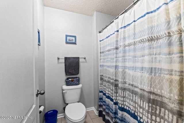 bathroom with a textured ceiling, tile patterned floors, toilet, and walk in shower