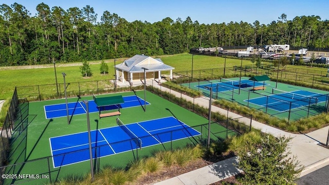 view of tennis court featuring a lawn