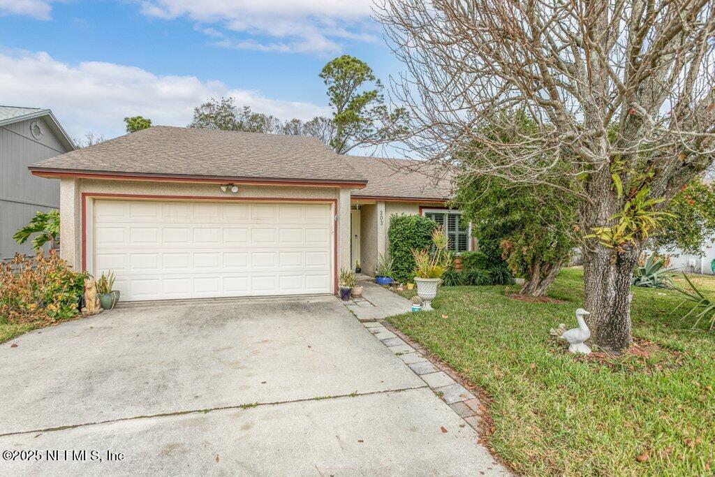 single story home featuring a garage and a front lawn