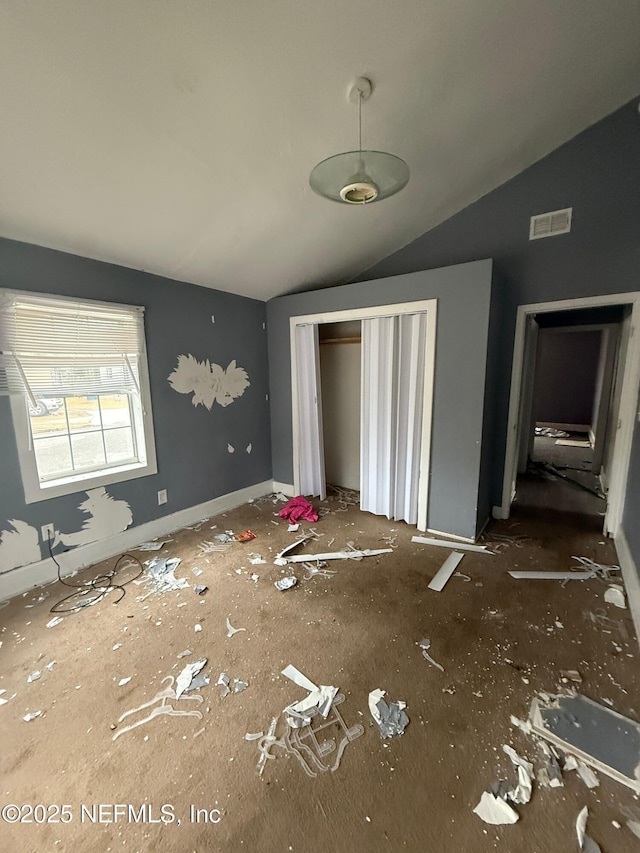 unfurnished bedroom with lofted ceiling and a closet