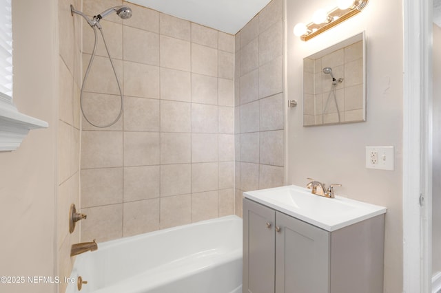 bathroom with tiled shower / bath and vanity