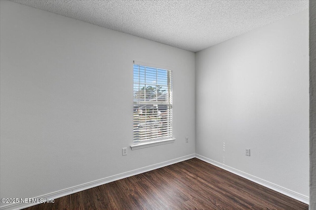 empty room with hardwood / wood-style floors and a textured ceiling