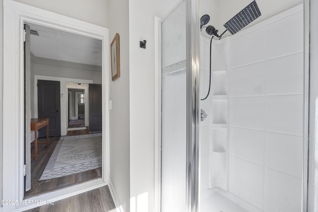 bathroom featuring wood-type flooring and a shower