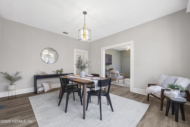 dining area featuring a notable chandelier and dark wood-type flooring