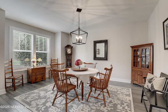 dining space featuring light wood-style floors, a chandelier, and baseboards