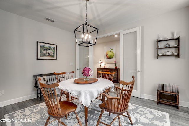 dining space featuring visible vents, baseboards, and wood finished floors