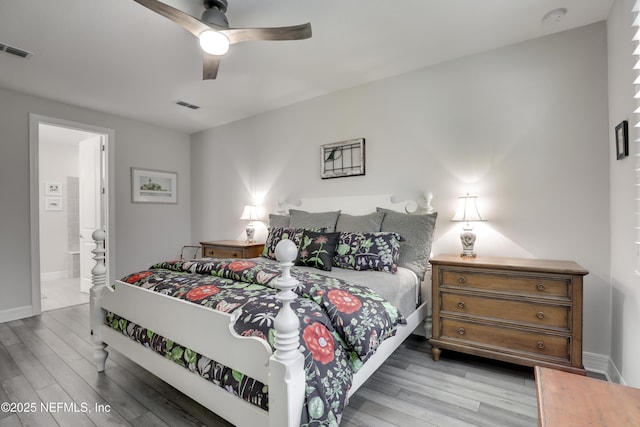 bedroom featuring connected bathroom, wood finished floors, visible vents, and baseboards