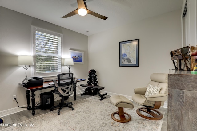 home office with a ceiling fan, baseboards, and wood finished floors