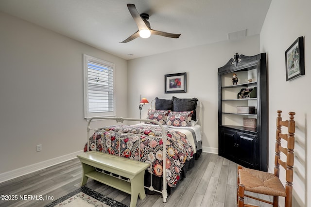 bedroom with light wood-style floors, visible vents, ceiling fan, and baseboards