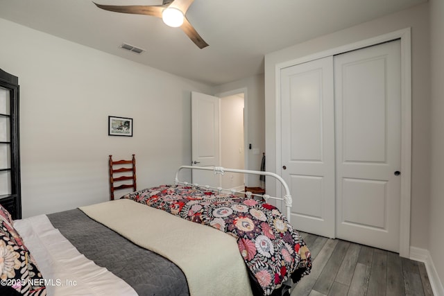 bedroom featuring ceiling fan, visible vents, baseboards, light wood-style floors, and a closet