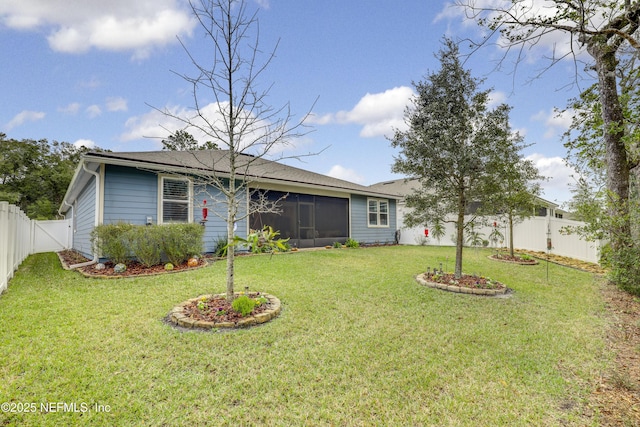 exterior space featuring a front yard, a sunroom, and a fenced backyard