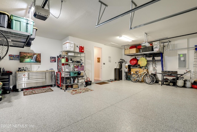 garage with a garage door opener, electric panel, and a workshop area