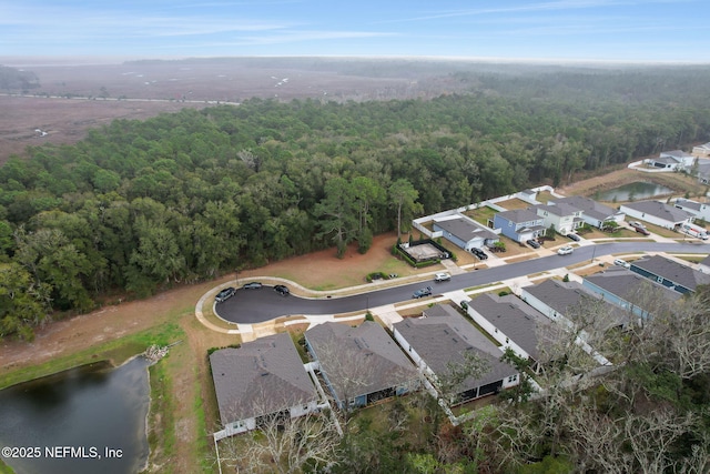 aerial view featuring a residential view, a water view, and a view of trees