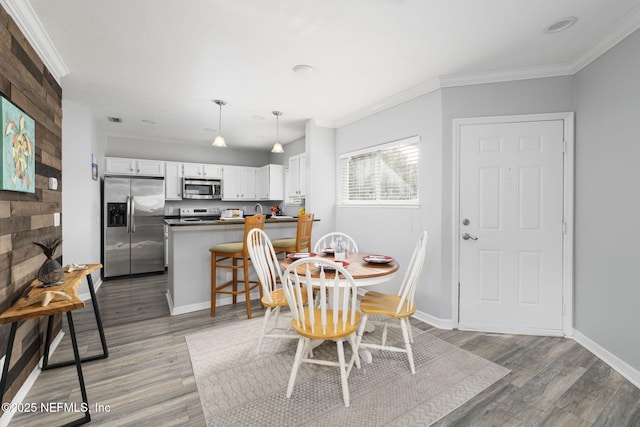 dining space featuring ornamental molding and hardwood / wood-style floors