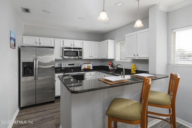 kitchen with stainless steel appliances, a breakfast bar area, and white cabinets