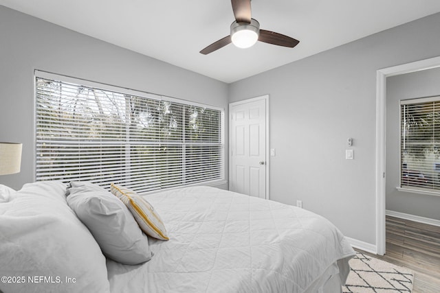 bedroom with multiple windows, ceiling fan, and light wood-type flooring