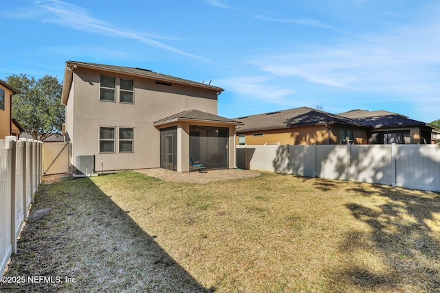 rear view of property featuring cooling unit, a lawn, a sunroom, and a patio