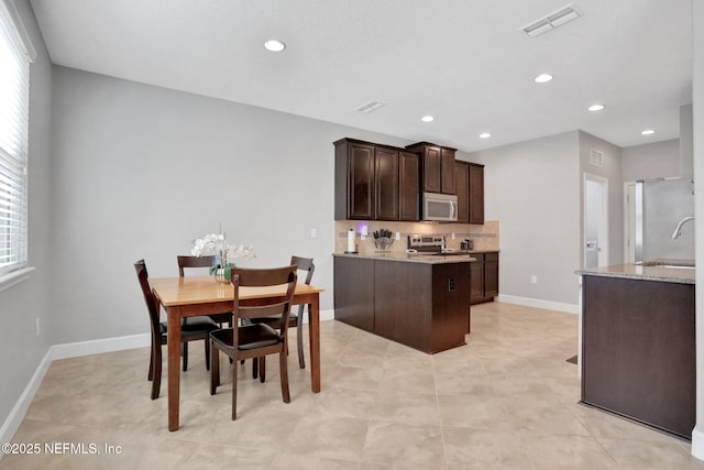 dining area featuring sink and light tile patterned floors