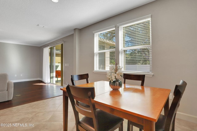 dining room with a textured ceiling and light tile patterned flooring