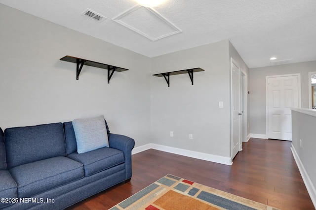 living room featuring dark hardwood / wood-style flooring and a textured ceiling