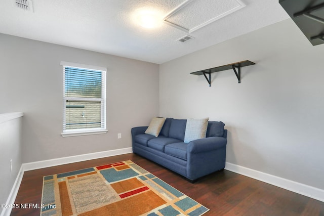 sitting room with dark wood-type flooring and a textured ceiling