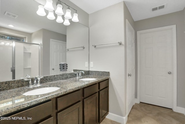 bathroom featuring vanity, a shower with shower door, and tile patterned flooring