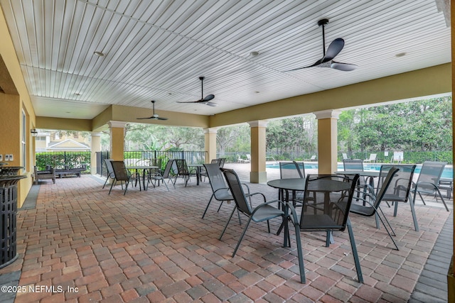 view of patio with a community pool and ceiling fan