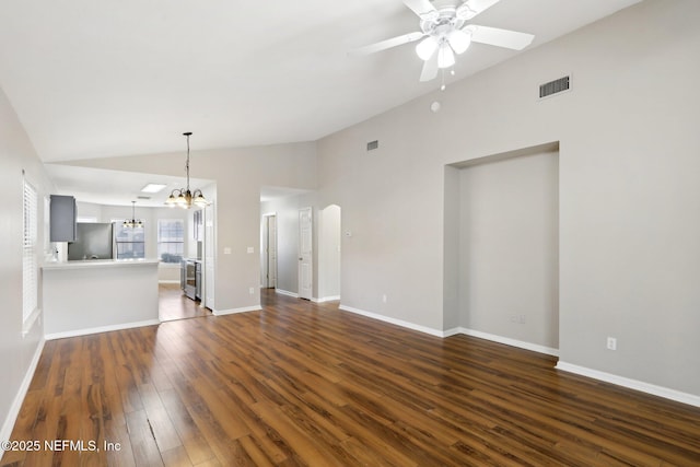 unfurnished living room with lofted ceiling, dark wood-type flooring, and ceiling fan with notable chandelier