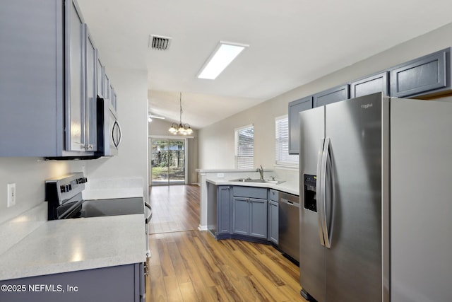 kitchen with decorative light fixtures, sink, a chandelier, light hardwood / wood-style floors, and stainless steel appliances