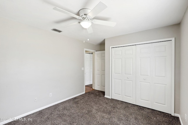 unfurnished bedroom with dark colored carpet, ceiling fan, and a closet