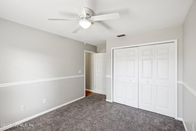 unfurnished bedroom with ceiling fan, a closet, and dark colored carpet