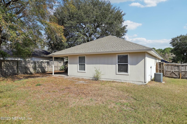 back of house featuring central AC unit and a lawn