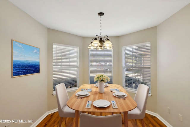 dining space featuring dark hardwood / wood-style floors and a notable chandelier