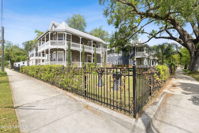 view of front of house featuring metal roof and a fenced front yard