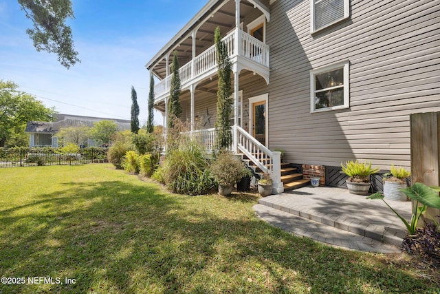 view of yard with a balcony and fence