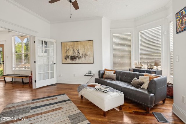 living room with hardwood / wood-style floors, visible vents, and a ceiling fan