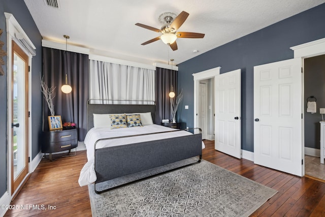 bedroom with baseboards, visible vents, ceiling fan, and wood-type flooring