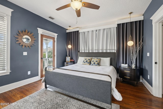 bedroom with baseboards, visible vents, and wood finished floors