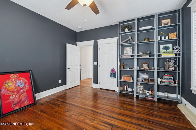 interior space featuring baseboards, ceiling fan, and wood finished floors